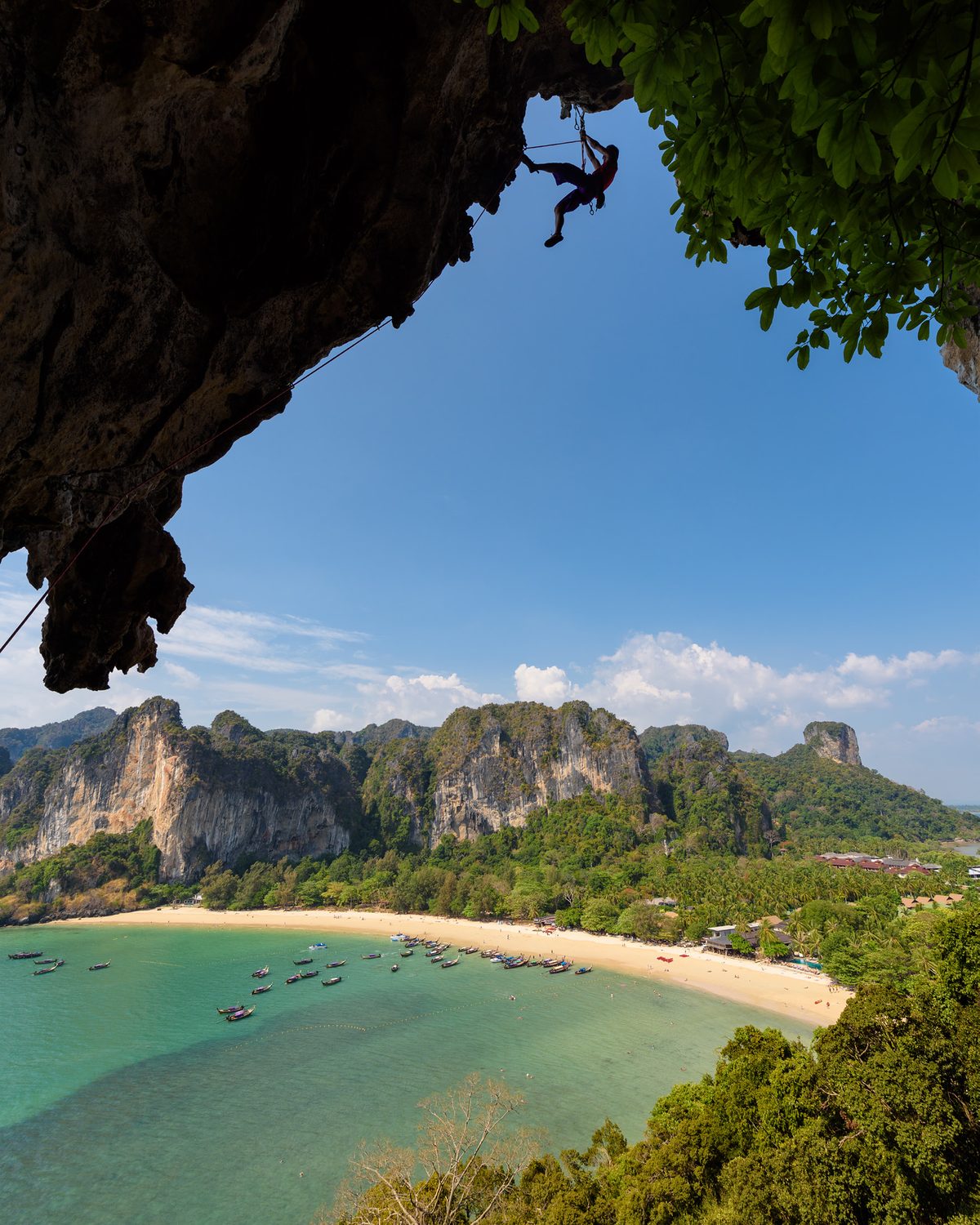 View of Railay Beach and limestone cliffs framed by a cave overhang in Krabi